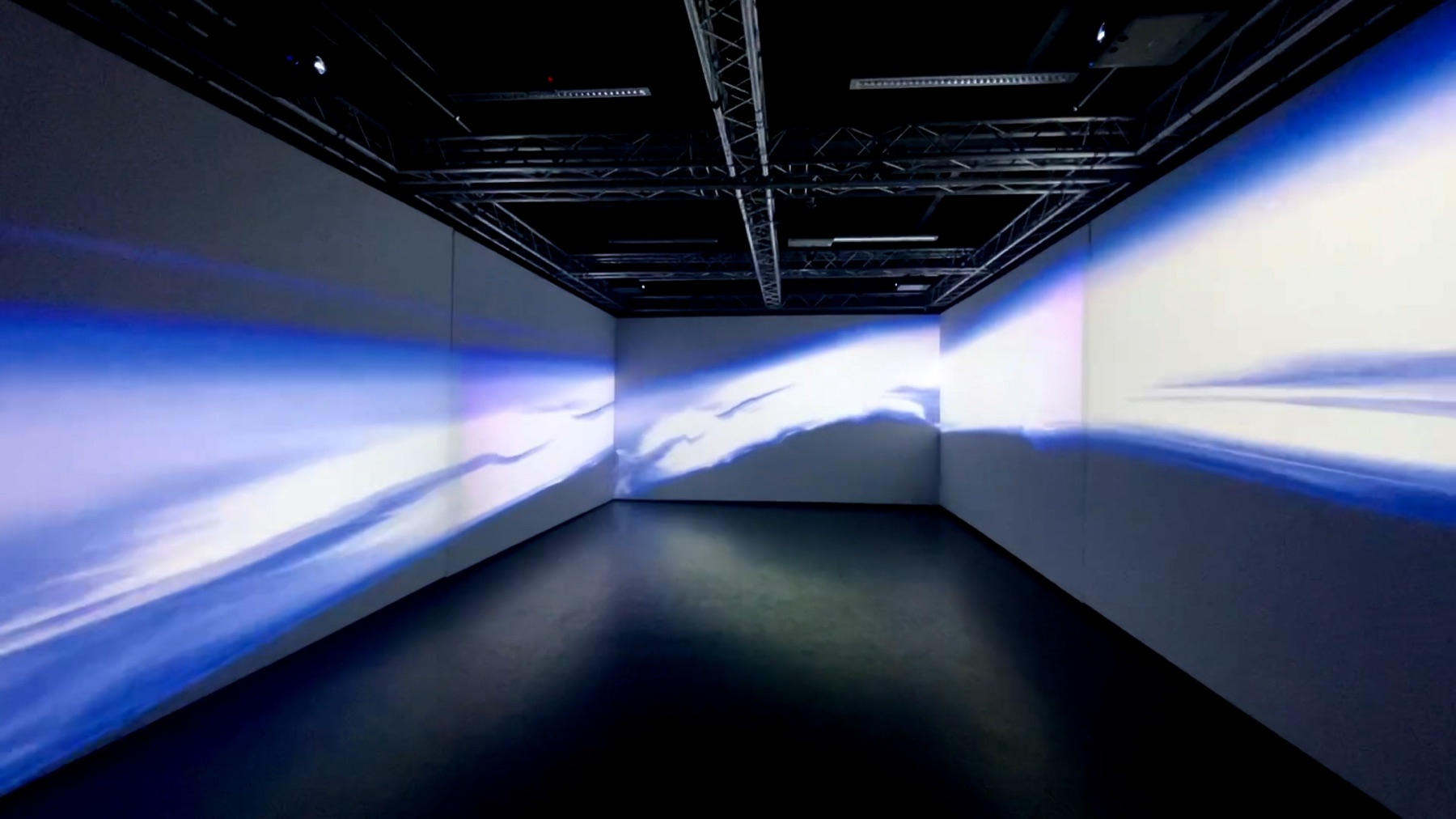 Empty diffusion room, wrap-around wave-form projection on three walls.